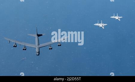 Qatar Emiri Air Force F-15QAs fly alongside a U.S. Air Force B-52H Stratofortress above the Arabian Gulf, March 29, 2022. The presence of the B-52H showcases U.S. Central Command's ability to deliver combat airpower at a moment's notice, as well as its commitment to partners and regional security. (U.S. Air Force photo by Staff Sgt. Joseph Pick) Stock Photo