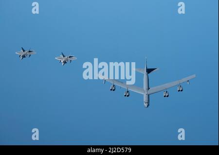 U.S. Air Force F-22 Raptors fly alongside a U.S. Air Force B-52H Stratofortress above the Arabian Gulf, March 29, 2022. The presence of the B-52H showcased U.S. Central Command's ability to deliver combat airpower at a moment's notice, as well as its commitment to partners and regional security. (U.S. Air Force photo by Staff Sgt. Joseph Pick) Stock Photo