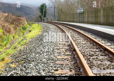 Railway track by the platform of the small train halt,that winds it's way through the Welsh Highland mountains, to and from Snowdonia. Stock Photo