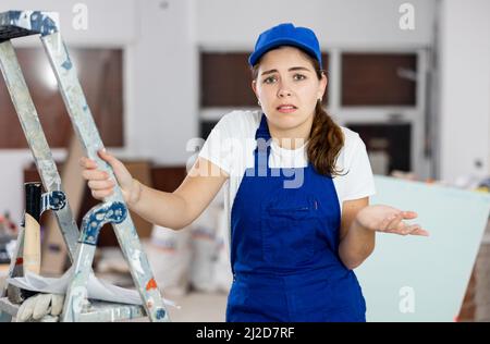 Sad woman builder standing in construction site Stock Photo