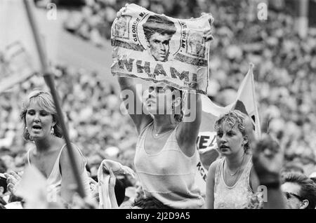 Fans enjoy Wham ! The Farewell Concert at Wembley Stadium, London on 28th June 1986. Wham !,  (singer George Michael, and singer/guitarist Andrew Ridgeley) played their final concert as Wham !, although Andrew joined George as a guest on a few later George Michael solo shows.  Picture taken 28th June 1986 Stock Photo