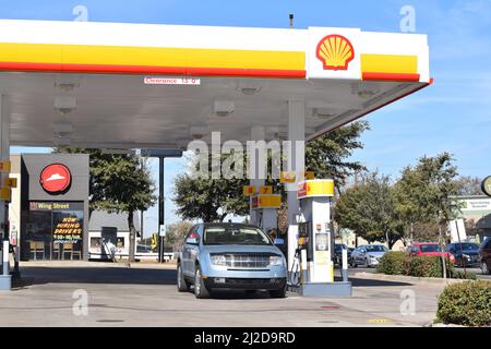 Customer pumping gas at a Shell gas station in Dallas, TX Stock Photo