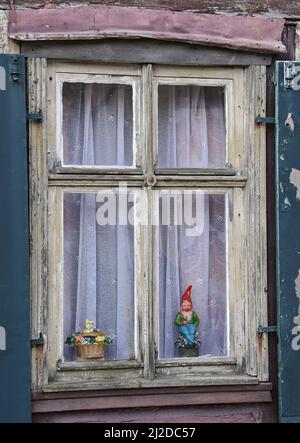 Templin, Germany. 30th Mar, 2022. A garden gnome stands behind a window of an old half-timbered house in the Rühlstraße of the town in the uckermark. Rühlstraße is home to the oldest houses in the town. They were built after the town fire of 1735 and the subsequent reconstruction of the street network. Almost all of these half-timbered houses have been lovingly restored. Templin is located in the north of the state of Brandenburg and has about 16000 inhabitants. Credit: Patrick Pleul/dpa-Zentralbild/ZB/dpa/Alamy Live News Stock Photo