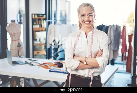 Ill have you looking like a million dollars. Shot of a successful young fashion designer in her workshop. Stock Photo
