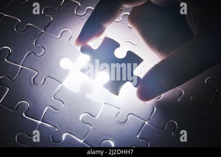 The last piece to place. Conceptual shot of a persons hand building a puzzle. Stock Photo