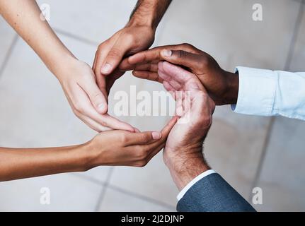 Working together makes productivity flow. Cropped shot of a group of unrecognizable people joining hands in solidarity. Stock Photo