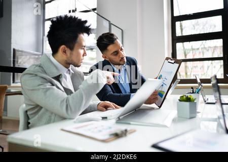 Financial Data Analysts Discussing Business In Office Stock Photo