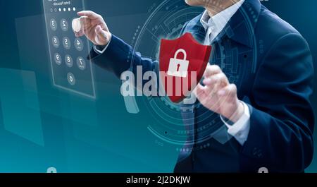 Businessman entering passcode while the other hand holding virtual red metal shield with padlock in system security and data protection concept. Stock Photo