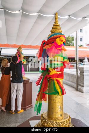 Bangkok, Thailand - Mar 29, 2022: The duplicated golden pillars in front of the original one in the temple of  Bangkok City Pillar Shrine for people t