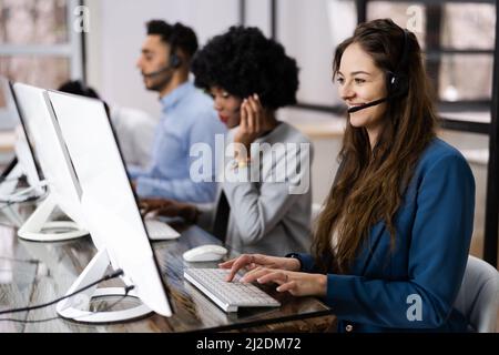 Positive Customer Services Agent With Headset Working In A Call Center Stock Photo