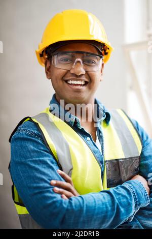 You can expect greatness whenever he works on a project. Shot of a engineer wearing protective gear on a construction site. Stock Photo
