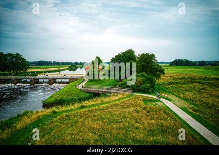 Drone view of the river Vecht, green grass, trees, beautiful blue sky and cycle path through the Vecht valley. Bridge and weir in the river. Dalfsen Stock Photo