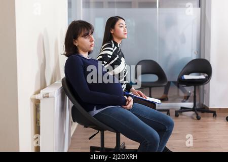 Recruiter people waiting in lobby office during company job interview holding recruitment files preparing for hiring meeting. Multiethnic group of candidates recruiting for business career opportunity Stock Photo