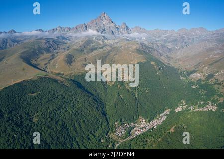 AERIAL VIEW. Monte Viso (3841m) viewed from the northeast with the city of Crissolo in the Po Valley. Province of Cuneo, Piedmont, Italy. Stock Photo