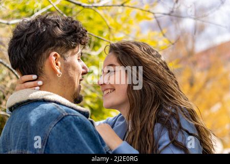 A loving couple smiling and looking at each other in a park Stock Photo