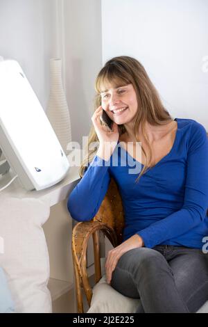 Woman smartphone light therapy Stock Photo