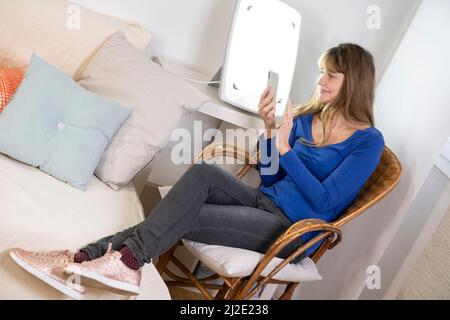 Woman smartphone light therapy Stock Photo
