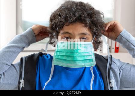 Coronavirus epidemic. boy holds a medical protective mask face mask against: virus, ill, epidemic, flu. coronavirus. face mask for protection coronavirus outbreak Stock Photo