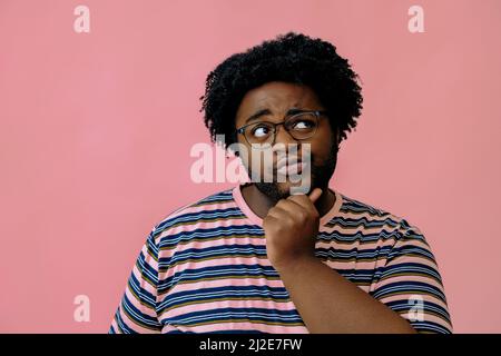 young happy african american man posing in the studio over pink background male model Stock Photo