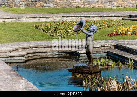 Statue of a Cherub  fountain in a pond at marine cove gardens at Burnham on sea, Somerset, United Kingdom Stock Photo