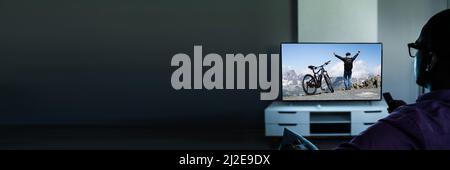 African Man Watching TV Movie Or Television In Glasses Stock Photo