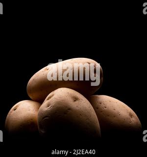Low light macro photo of potatoes on a black background Stock Photo