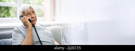 Senior Old Man Talking On Landline Telephone Stock Photo