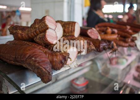 Stock of food such as dried meat and sausages on the display above empty refrigerators in Lviv, Ukraine. Low stock of food in ukraine due to war. Stock Photo