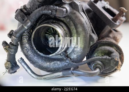 Old and worn car turbo charger. View of the flange on exhaust manifold