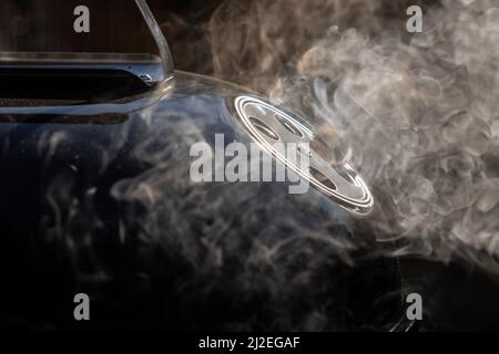 Smoke coming out from ventilation opening of a smoker grill. Round ventilation opening in open position to allow exit of smoke fumes. Stock Photo