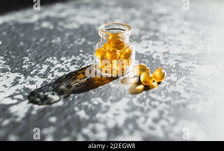 Cod liver capsules laid out in a glass bottle  Stock Photo