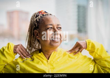 Senior African woman doing warm up exercises before running in the city - Elderly Sporty people lifestyle concept Stock Photo