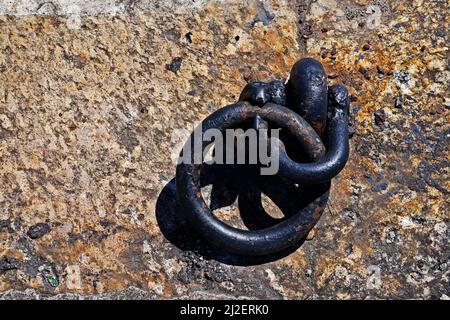 Old iron mooring ring on a stone dock Stock Photo