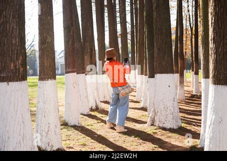 Elder lady taking a picture in a park in Kunming Stock Photo