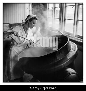 WW2 An Auxiliary Territorial Service (ATS) Female Woman Food Preparation cook chef at work in an army cookhouse, stirring a large cauldron pot of stew, 10 December 1942. The Auxiliary Territorial Service (ATS):  Female ATS cook at work in an army cookhouse seen stirring a large cauldron of stew. Stock Photo