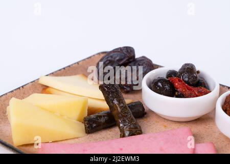 Close-up view of walnuts, olives, tomato paste, cheese slices, wrap, ham, dried apricots, date and cheddar cheeses on isolated white background, oppos Stock Photo
