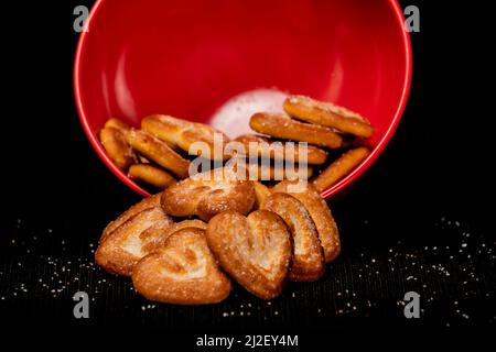 Hearts Shaped Biscuit In Red Round Bowl, Biscuits Heap, Isolated on Black Background Stock Photo