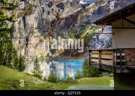 Amazing tourquise Oeschinnensee lake, wooden chalet and Swiss Alps, Berner Oberland, Switzerland. Stock Photo