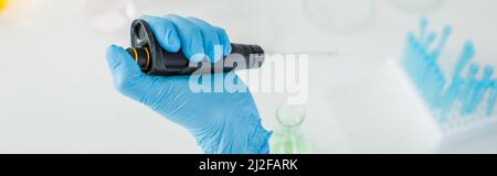 cropped view of scientist in blue latex glove using micropipette in lab, banner,stock image Stock Photo