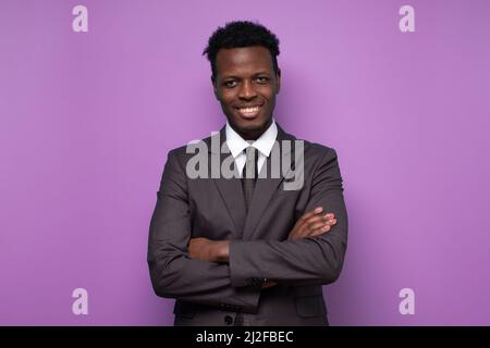 Smiling african man wearing suit looking at camera. Portrait of black confident man at home. Successful entrepreneur feeling satisfied. Stock Photo
