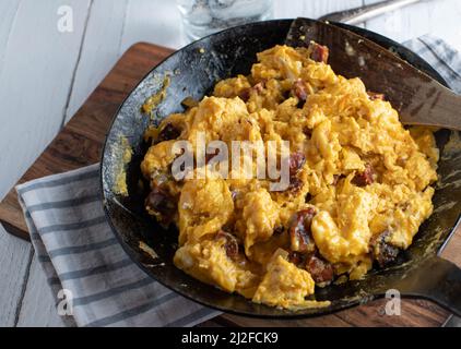 Scrambled eggs with chorizo in cast iron pan Stock Photo
