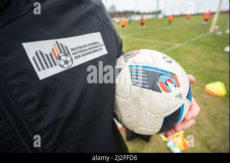 Jessen, Germany. 01st Apr, 2022. A coach holds a ball in his arm during the training of the national team of mayors. This weekend, the team will play an international match against a selection of counterparts from Poland. At the same time, the training camp will be used to screen new players. Credit: Christian Modla/dpa/Alamy Live News Stock Photo