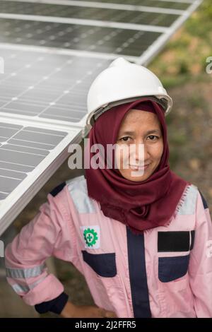 Junior electrical technician, Verawati (23), inspects and maintains solar panels on Karampuang Island, Indonesia, which were installed as part of the Stock Photo