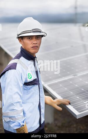 Junior electrical technician, Aldi (25), inspects and maintains solar panels on Karampuang Island, Indonesia, which were installed as part of the Gree Stock Photo