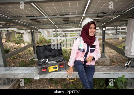 Junior electrical technician, Verawati (23), inspects and maintains solar panels on Karampuang Island, Indonesia, which were installed as part of the Stock Photo