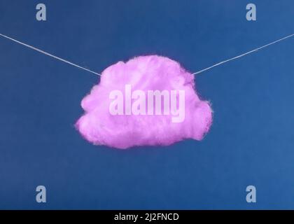 Purple cloud on strings on blue sky background. Imagination, fantasy, dreaming concept in surreal style. High quality photo Stock Photo