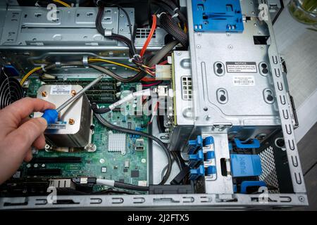 a screwdriver is held in an unscrewed PC Stock Photo