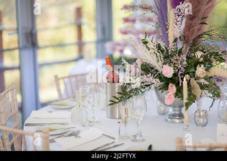 Flower table decorations for holidays and wedding dinner. Table set for holiday, event, party or wedding reception in a restaurant. Stock Photo