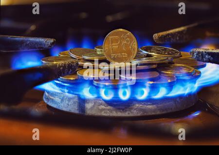 gas stove burner with russian ruble coins on top, burning gas Stock Photo