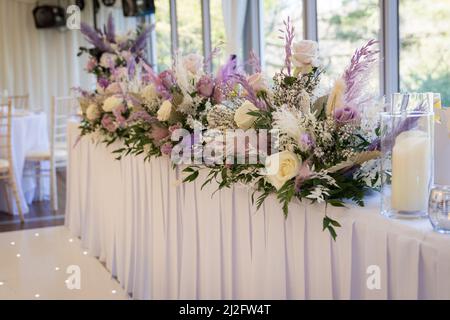Flower table decorations for holidays and wedding dinner. Table set for holiday, event, party or wedding reception in a restaurant. Stock Photo